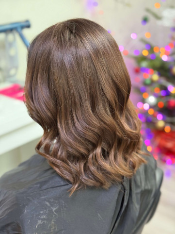 Enhance your look this festive season with this stunning soft brown hair color and loose waves, styled to perfection by The Colour Works Hair Salon in York Elegant loose waves with a natural brown hair colour featuring soft highlights, styled by The Colour Works Hair Salon in York