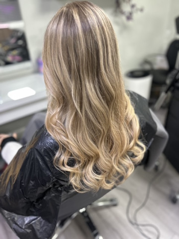 Achieve a flawless blonde look with cool, ashy tones and natural highlights, expertly styled by The Colour Works Hair Salon in York Blonde hair with cool, ashy tones and natural highlights styled in soft waves at The Colour Works Hair Salon in York